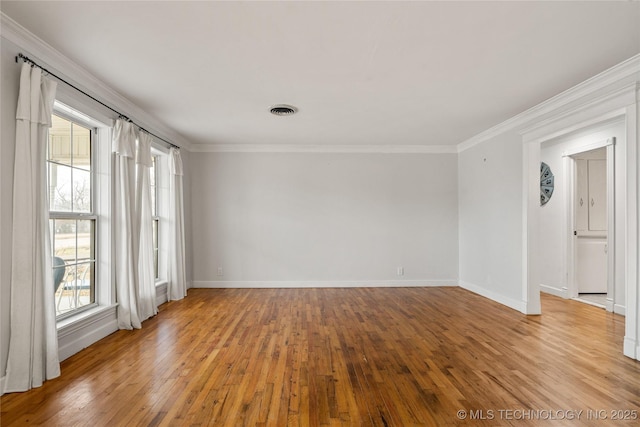 empty room with ornamental molding and light wood-type flooring