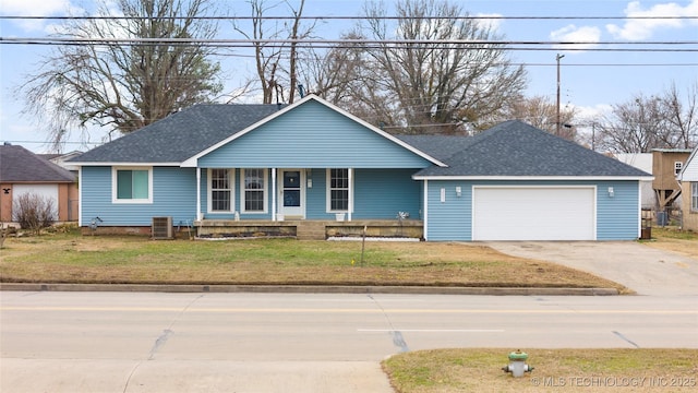 view of front of home with a garage, central AC unit, and a front lawn