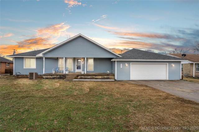 ranch-style home featuring a garage, a yard, covered porch, and central air condition unit