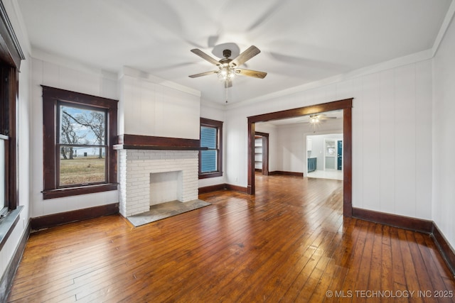 unfurnished living room featuring ceiling fan, hardwood / wood-style floors, and a fireplace