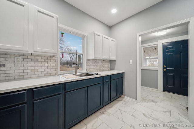 kitchen with tasteful backsplash, sink, and white cabinets