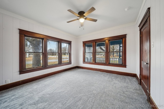 carpeted empty room featuring crown molding and ceiling fan