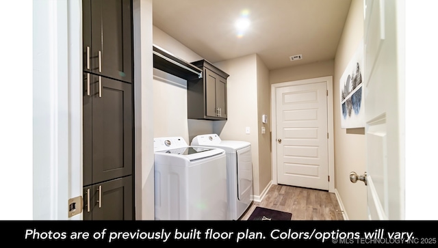 clothes washing area featuring light hardwood / wood-style flooring, cabinets, and washing machine and clothes dryer