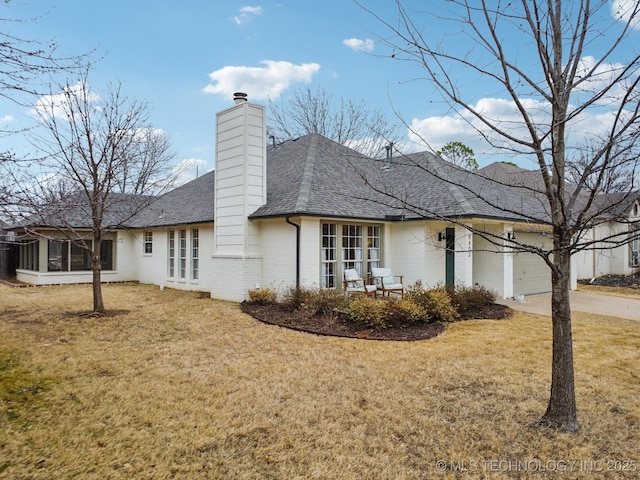 view of property exterior with a garage, a lawn, and a sunroom