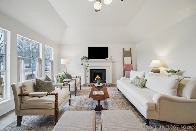 living room with vaulted ceiling, a brick fireplace, and ceiling fan