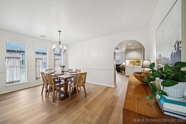 dining space with a chandelier and light hardwood / wood-style flooring