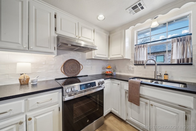 kitchen featuring sink, white cabinetry, electric range, light hardwood / wood-style floors, and decorative backsplash