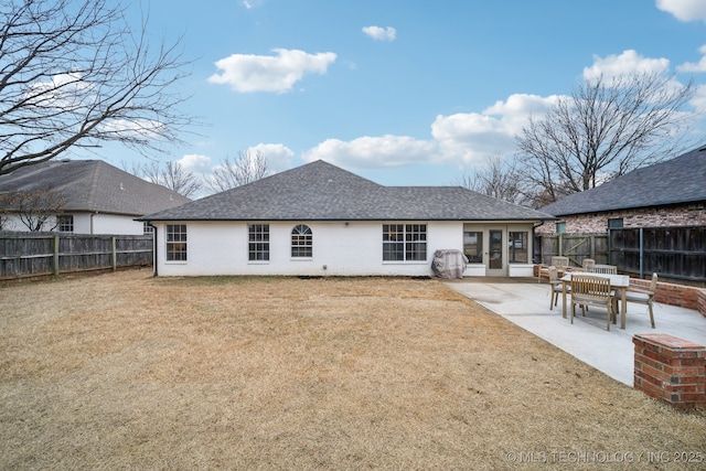 back of house featuring a patio area and a lawn