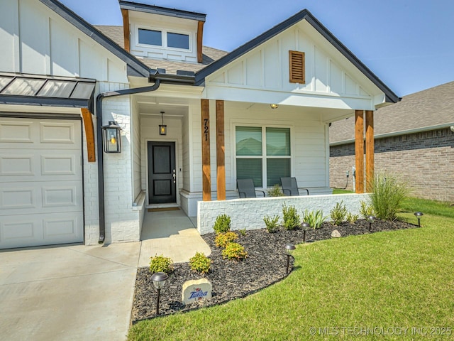 doorway to property with a yard, a garage, and a porch