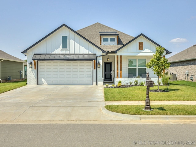 view of front of property featuring a garage, central AC, and a front lawn