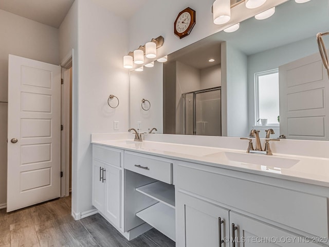 bathroom featuring walk in shower, wood-type flooring, and vanity