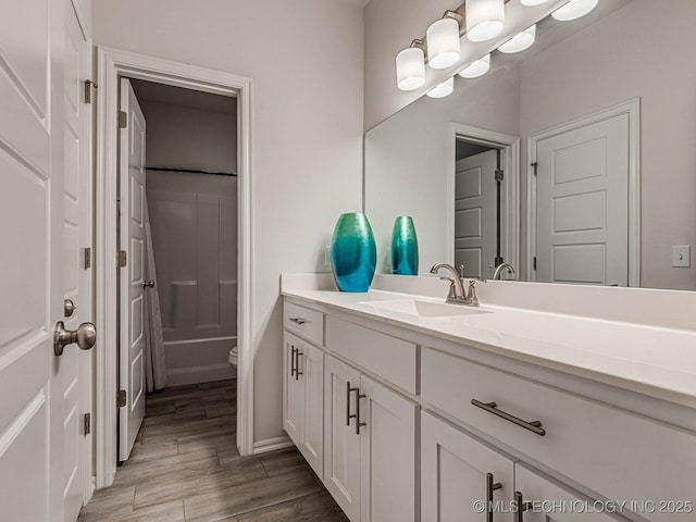 full bathroom featuring vanity, hardwood / wood-style flooring, bathing tub / shower combination, and toilet