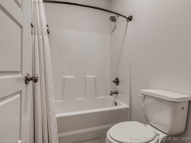 bathroom featuring toilet and shower / bath combo with shower curtain