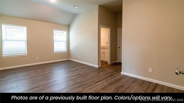 spare room featuring vaulted ceiling and dark wood-type flooring