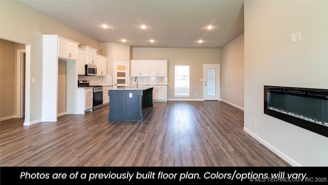 kitchen featuring stainless steel appliances, sink, a center island with sink, and white cabinets