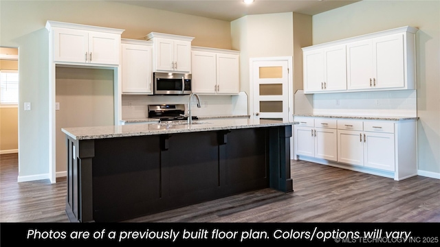 kitchen featuring white cabinetry, tasteful backsplash, stainless steel appliances, and a center island with sink