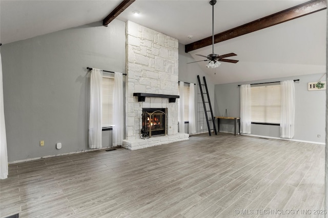 unfurnished living room with high vaulted ceiling, light hardwood / wood-style flooring, beamed ceiling, ceiling fan, and a fireplace