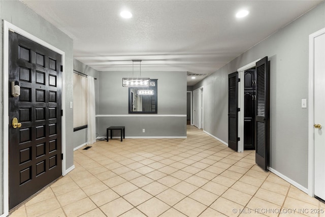 foyer entrance featuring a textured ceiling and light tile patterned floors