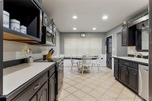 kitchen featuring light tile patterned flooring, appliances with stainless steel finishes, sink, and dark brown cabinets