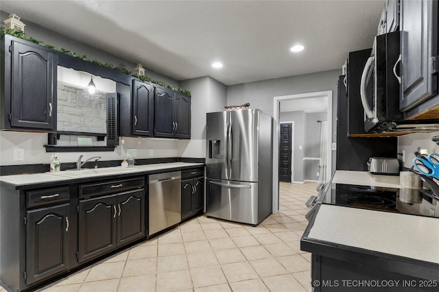 kitchen featuring appliances with stainless steel finishes, sink, and light tile patterned floors