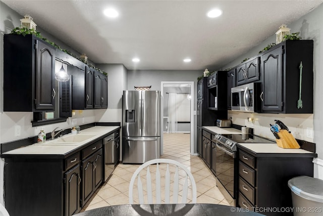 kitchen with appliances with stainless steel finishes, sink, and light tile patterned floors