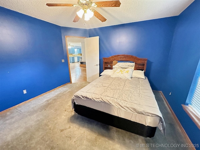 carpeted bedroom featuring ceiling fan and a textured ceiling