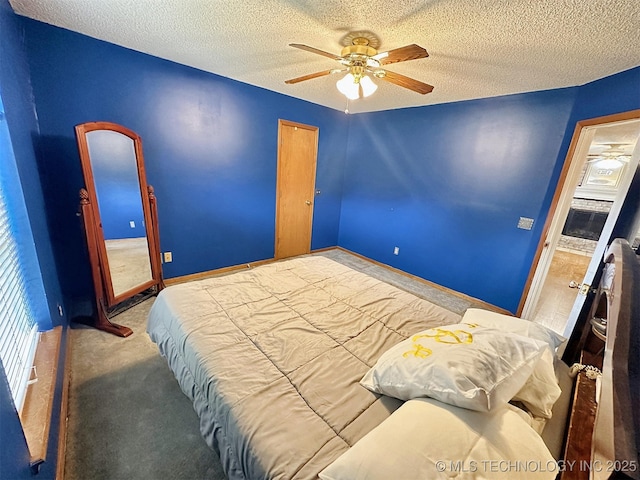 carpeted bedroom featuring ceiling fan and a textured ceiling