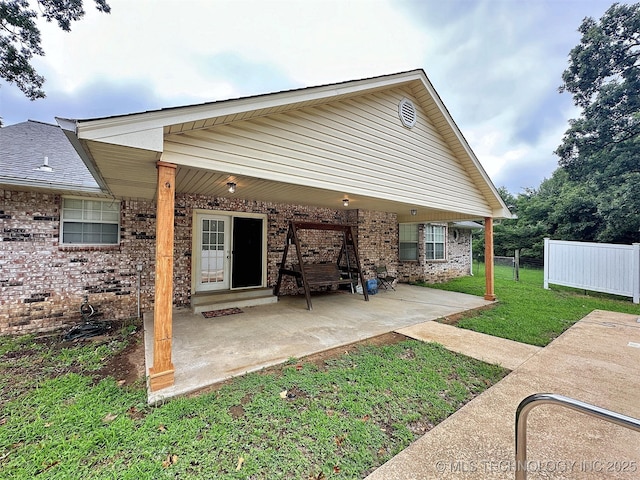 back of house with a yard and a patio