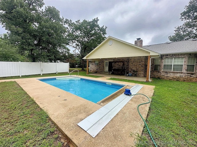 view of swimming pool with a yard and a patio area