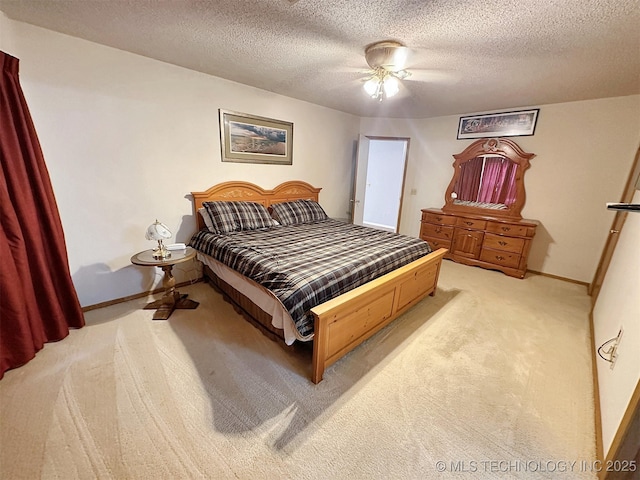 carpeted bedroom featuring ceiling fan and a textured ceiling