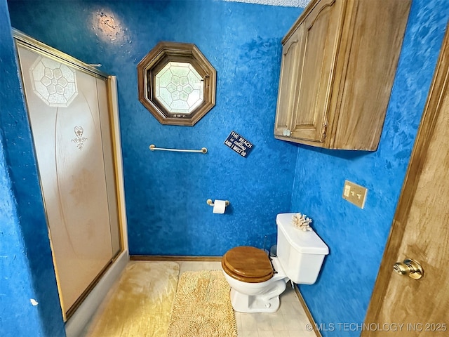 bathroom featuring walk in shower and toilet