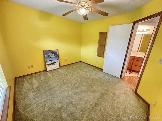 unfurnished bedroom featuring ceiling fan, ensuite bathroom, light carpet, and a textured ceiling