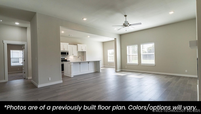 unfurnished living room featuring ceiling fan, wood-type flooring, and sink