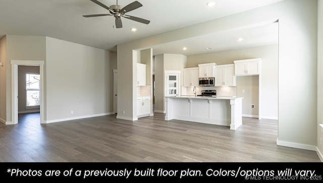 kitchen featuring white cabinetry, stainless steel appliances, tasteful backsplash, and light wood-type flooring