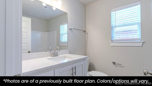 bathroom with vanity, toilet, and walk in shower