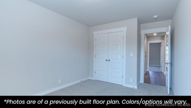 unfurnished bedroom with light colored carpet and a closet