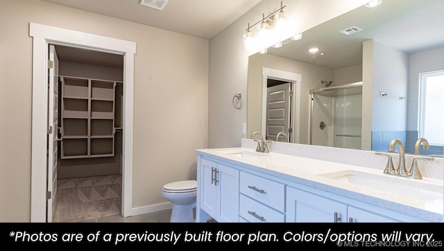 bathroom featuring tile patterned floors, vanity, toilet, and a shower with shower door