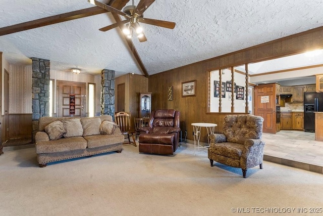 living room with ceiling fan, light colored carpet, a textured ceiling, and wood walls