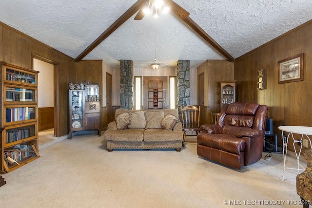 carpeted living room featuring ceiling fan, beam ceiling, wooden walls, and a textured ceiling