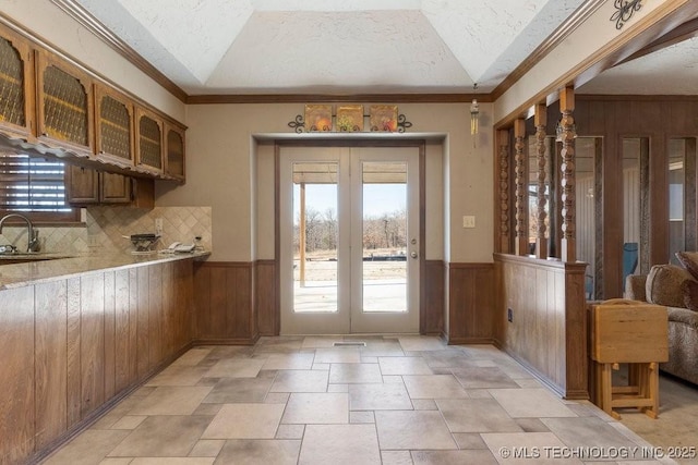 interior space featuring plenty of natural light, wooden walls, and a textured ceiling