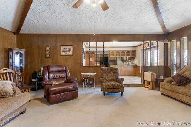 living room with beamed ceiling, wooden walls, carpet, and a textured ceiling