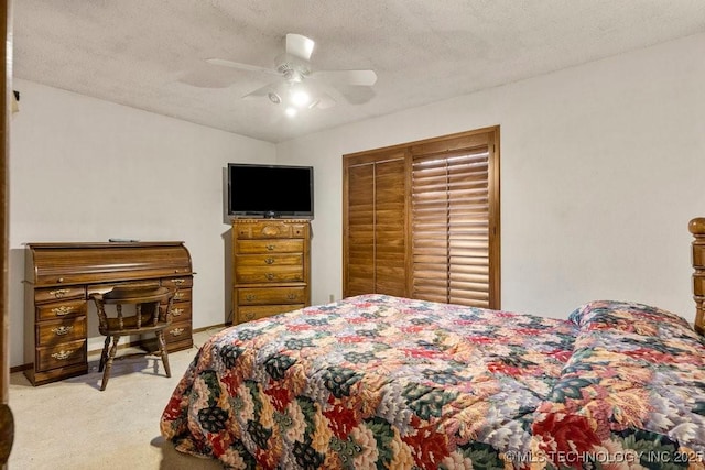 bedroom with light carpet, ceiling fan, a closet, and a textured ceiling