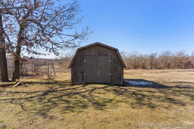 view of outbuilding featuring a rural view and a yard