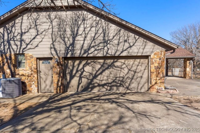 view of side of property featuring a garage and cooling unit