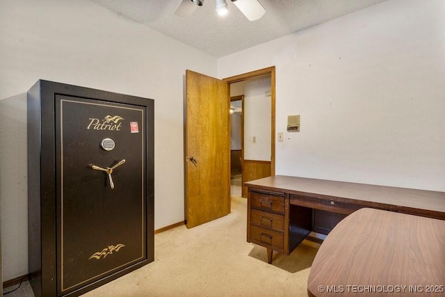 carpeted office space featuring ceiling fan and a textured ceiling