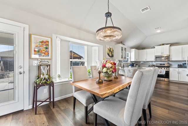 dining area with dark hardwood / wood-style floors, vaulted ceiling, and a notable chandelier