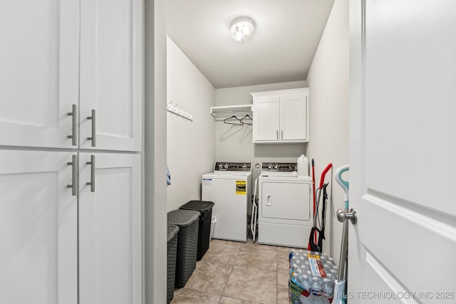 laundry room featuring cabinets, light tile patterned floors, and independent washer and dryer