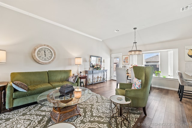 living room featuring vaulted ceiling, dark wood-type flooring, and a chandelier