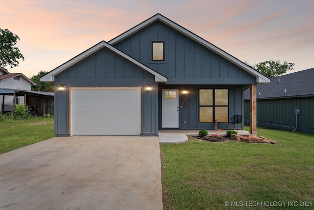 203 W Monroe Ave, Mcalester, OK 74501 - view of front facade featuring board and batten siding, an attached garage, concrete driveway, covered porch, and a lawn