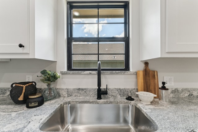 203 W Monroe Ave, Mcalester, OK 74501 - kitchen view of a sink, white cabinetry, and light stone countertops